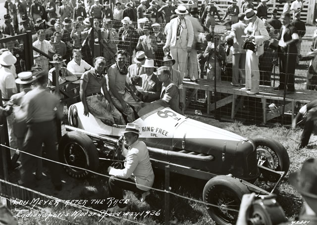 Despite the accumulation of fatigue and grime in the wake of a 500-mile race, Louis Meyer (in car, right) and his riding mechanic, Lawson Harris, are all smiles in Victory Lane following his 1936 Indianapolis 500 win. -- Photo by: No Photographer