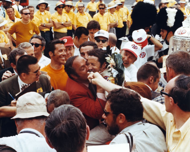 1969 Indianapolis 500 winner Mario Andretti receiving a kiss from car owner Andy Granatelli in victory lane. -- Photo by: No Photographer