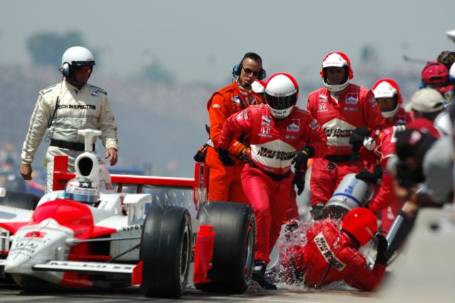 Sam Hornish Jr.'s crew pours water on a crew member after a fuel spill incident in the pits at the 90th running of the Indianapolis 500. -- Photo by: John Cote