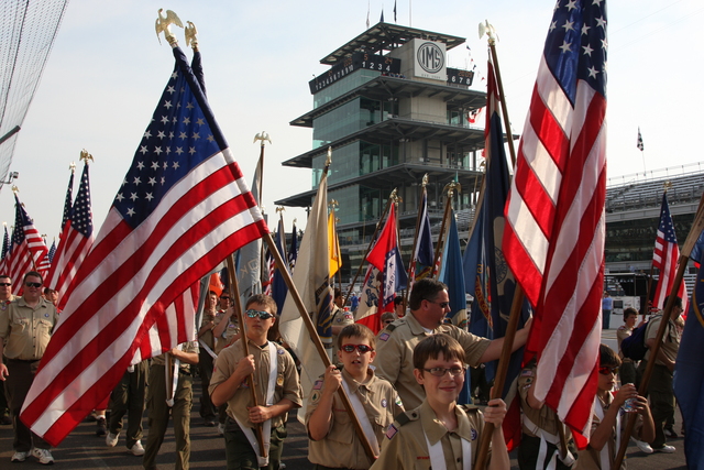 Boy Scout troops carries the stars and stripes in the pre-race parade. -- Photo by: Chris Jones