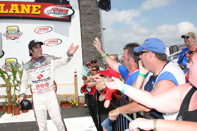 Dario Franchitti tosses a souvenir hat to fans in Victory Circle. -- Photo by: Ron McQueeney