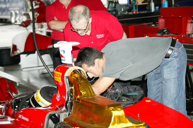 Jeff Simmons. driver of the No. 20 Patrick Racing Dallara Chevrolet helping with maintance on the car. -- Photo by: Ron McQueeney