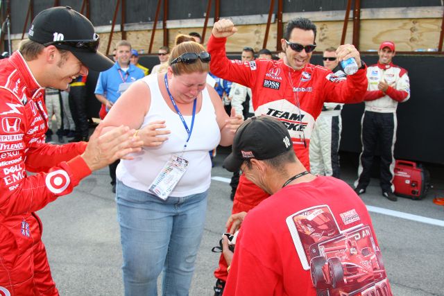 She says yes. Dan Wheldon and Helio Castroneves help a man propose to his girlfriend at the Kentucky Speedway on race day. -- Photo by: Shawn Payne