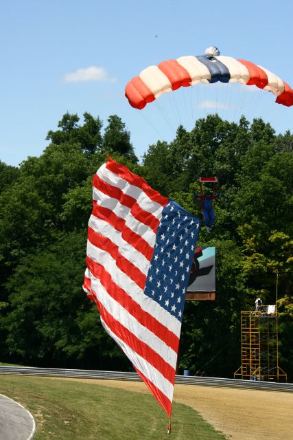 Sky diver displays the American flag before the start of the Honda 200 at Mid-Ohio. -- Photo by: Jim Haines