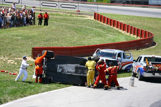 Safety crews help flip Marco Andretti's car right side up during the Honda 200 at Mid-Ohio. -- Photo by: Jim Haines