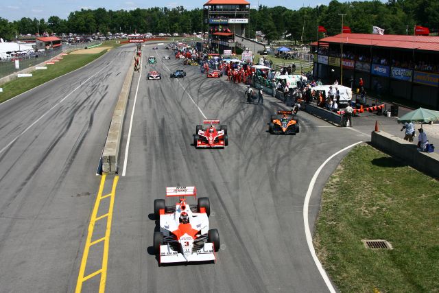 Helio Castroneves, Scott Dixon and Dario Franchitti race out of the pits during the Honda 200 at Mid-Ohio. -- Photo by: Jim Haines