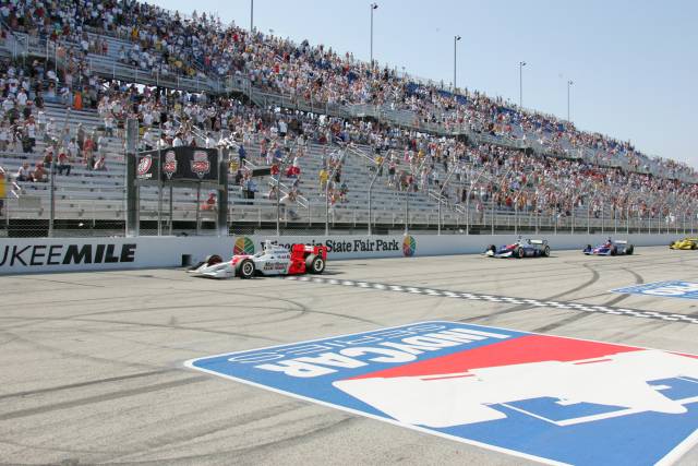 Sam Hornish Jr. takes the Checkers in front of Dario Franchitti and Tomas Scheckter. -- Photo by: Ron McQueeney