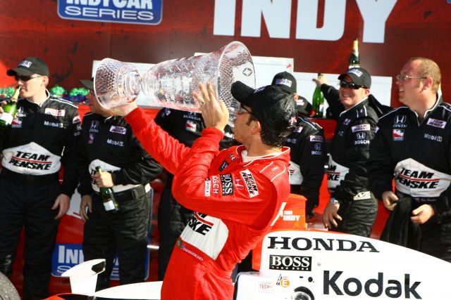 Helio Castroneves taking a drink from his trophy. -- Photo by: Jim Haines