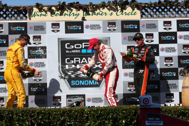 Scott Dixon, Ryan Hunter-Reay, and Simon Pagenaud spray the champagne in Victory Circle at Sonoma Raceway -- Photo by: Chris Jones