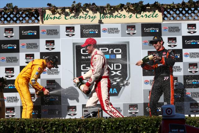 Scott Dixon, Ryan Hunter-Reay, and Simon Pagenaud spray the champagne in Victory Circle at Sonoma Raceway -- Photo by: Chris Jones