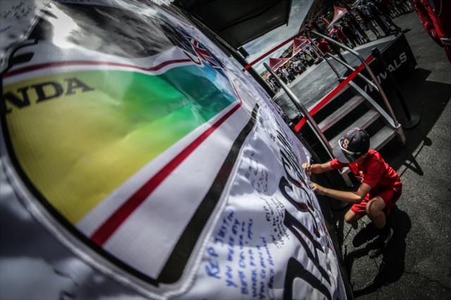A fan signs the Justin Wilson tribute flag in the INDYCAR Fan Village at Sonoma Raceway -- Photo by: Shawn Gritzmacher