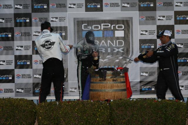 The champagne flies in Victory Lane within the podium of Simon Pagenaud, Graham Rahal, and Juan Pablo Montoya following the GoPro Grand Prix of Sonoma -- Photo by: Chris Jones