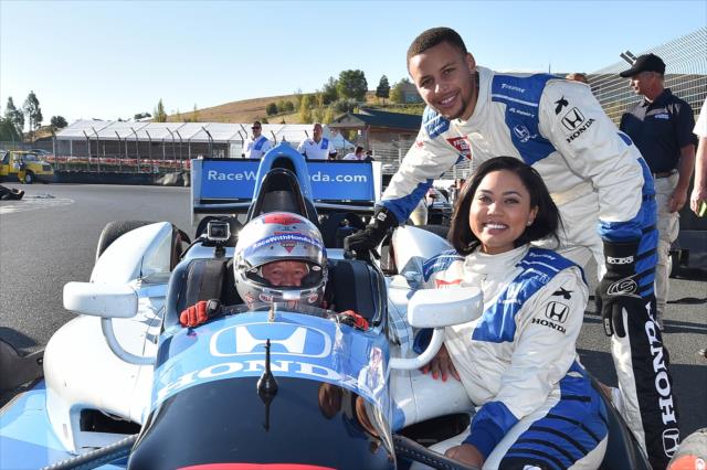 Grand Marshal Ayesha Curry, NBA star Stephan Curry, and INDYCAR legend Mario Andretti around the two-seater at Sonoma Raceway -- Photo by: Chris Owens
