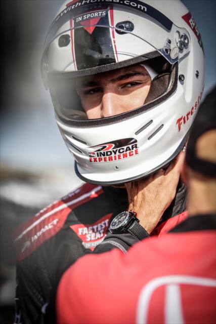 Golden State Warriors star Klay Thompson has his helmet tightened prior to his two-seater ride around Sonoma Raceway -- Photo by: Shawn Gritzmacher
