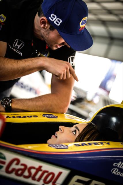Alexander Rossi shows Olympic gymnast Aly Raisman the finer points of his car in the Andretti Autosport garages at Sonoma Raceway -- Photo by: Shawn Gritzmacher