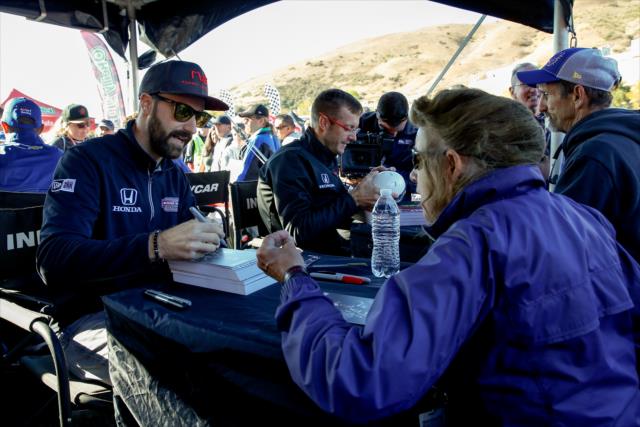 James Hinchcliffe signs an autograph for a fan during the autograph session in the INDYCAR Fan Village at Sonoma Raceway -- Photo by: Joe Skibinski