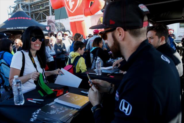 James Hinchcliffe signs an autograph for a fan during the autograph session in the INDYCAR Fan Village at Sonoma Raceway -- Photo by: Joe Skibinski