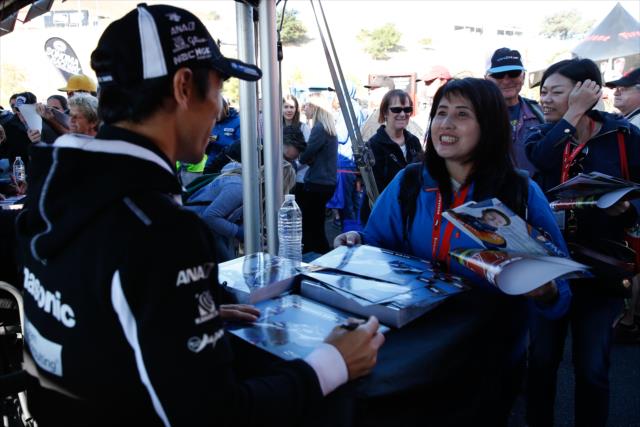 Takuma Sato signs an autograph for a  fan during the autograph session in the INDYCAR Fan Village at Sonoma Raceway -- Photo by: Joe Skibinski