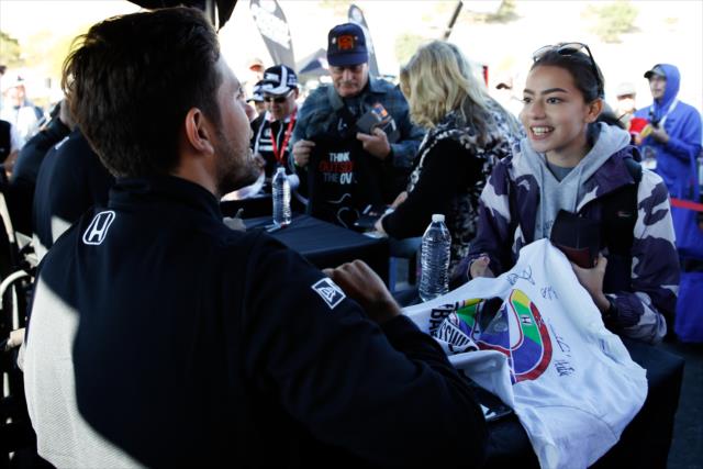 Carlos Munoz chats with a fan during the autograph session in the INDYCAR Fan Village at Sonoma Raceway -- Photo by: Joe Skibinski