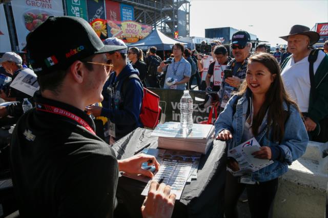 Patricio O'Ward signs an autograph for a fan during the autograph session in the INDYCAR Fan Village at Sonoma Raceway -- Photo by: Joe Skibinski