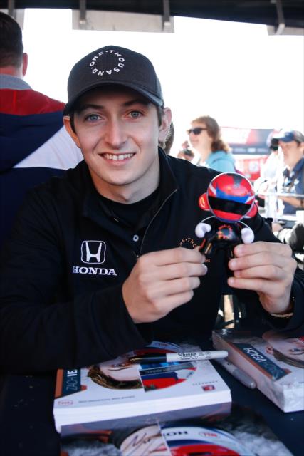 Zach Veach with a mini-figurine during the autograph session in the INDYCAR Fan Village at Sonoma Raceway -- Photo by: Joe Skibinski