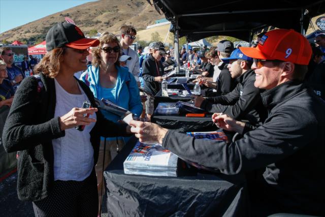 Scott Dixon signs an autograph for a fan during the autograph session in the INDYCAR Fan Village at Sonoma Raceway -- Photo by: Joe Skibinski