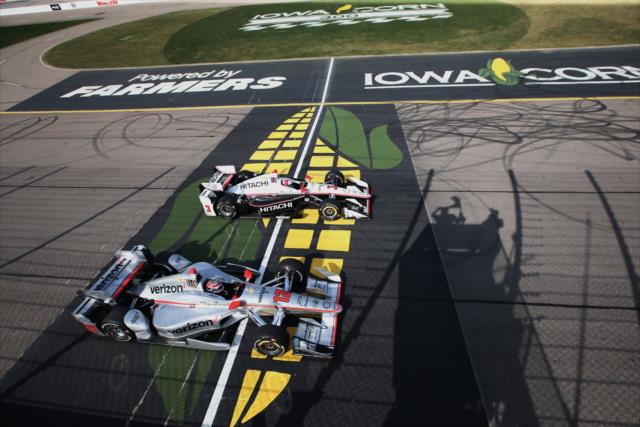 Will Power and Helio Castroneves streak across the start/finish line during the Iowa Corn 300 at Iowa Speedway -- Photo by: Chris Jones