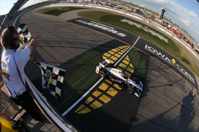 Helio Castroneves takes the twin checkers to win the Iowa Corn 300 at Iowa Speedway -- Photo by: Chris Jones