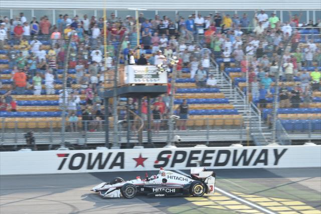 Helio Castroneves takes the twin checkers to win the Iowa Corn 300 at Iowa Speedway -- Photo by: Chris Owens