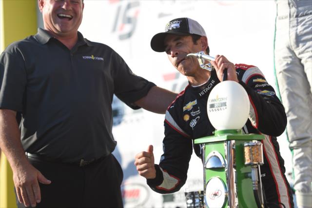 Helio Castroneves takes a sip from the winner's trophy in Victory Circle after winning the Iowa Corn 300 at Iowa Speedway -- Photo by: Chris Owens