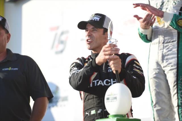 Helio Castroneves celebrates with the trophy in Victory Circle after winning the Iowa Corn 300 at Iowa Speedway -- Photo by: Chris Owens