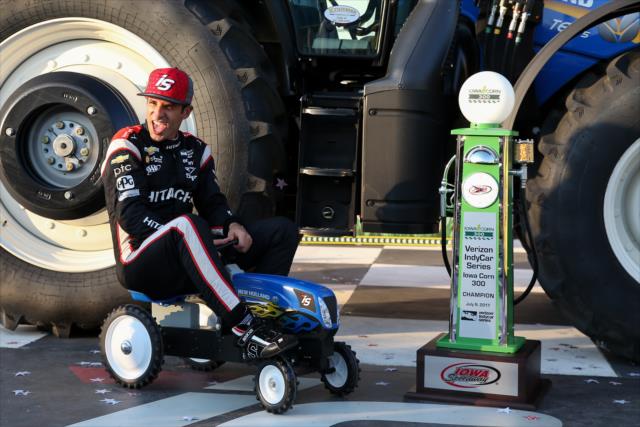 Helio Castroneves boards a mini-tractor in Victory Circle after winning the Iowa Corn 300 at Iowa Speedway -- Photo by: Joe Skibinski