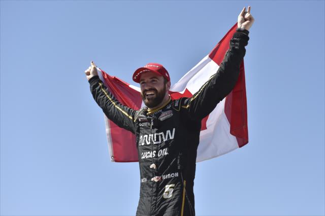James Hinchcliffe celebrates with the Canadian flag in Victory Circle after winning the Iowa Corn 300 at Iowa Speedway -- Photo by: Chris Owens