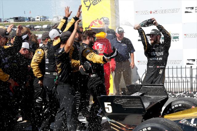 James Hinchcliffe sprays champagne over his Schmidt Peterson Motorsports crew in Victory Lane after winning the Iowa Corn 300 at Iowa Speedway -- Photo by: Joe Skibinski