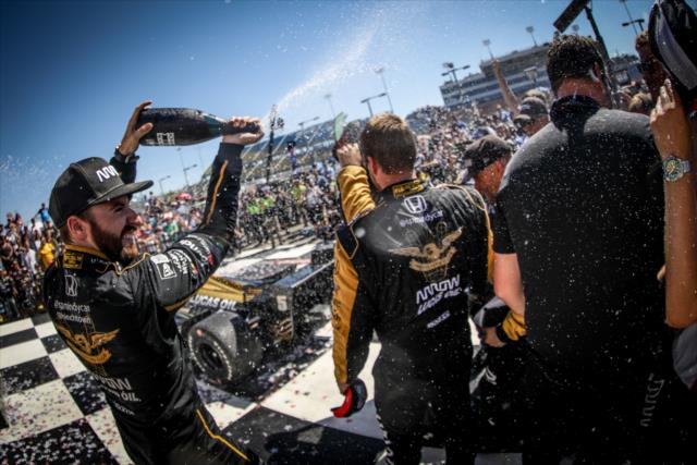 James Hinchcliffe sprays champagne over his crew in Victory Circle after winning the Iowa Corn 300 at Iowa Speedway -- Photo by: Shawn Gritzmacher