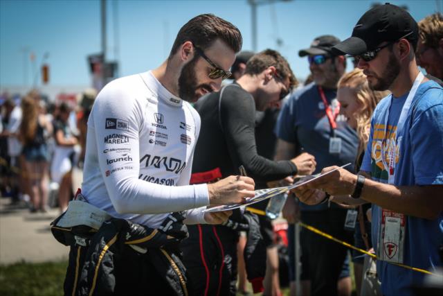 James Hinchcliffe and Will Power signs a quick autograph during pre-race festivities for the Iowa Corn 300 at Iowa Speedway -- Photo by: Shawn Gritzmacher