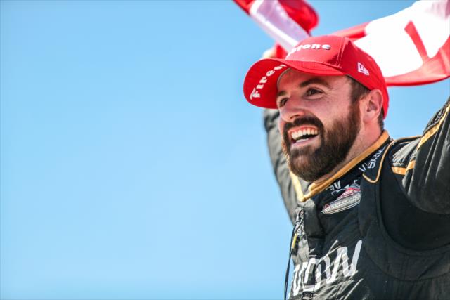 James Hinchcliffe flies the Canadian Flag high in Victory Circle after winning the Iowa Corn 300 at Iowa Speedway -- Photo by: Shawn Gritzmacher