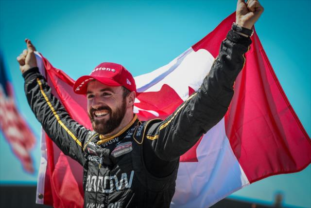 James Hinchcliffe flies the Canadian Flag high in Victory Circle after winning the Iowa Corn 300 at Iowa Speedway -- Photo by: Shawn Gritzmacher