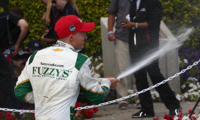 Mike Conway sprays the champagne following his victory -- Photo by: Chris Jones