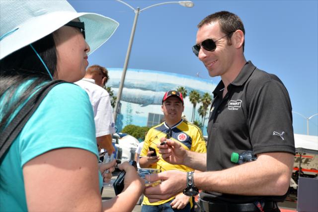 Simon Pagenaud signs some autographs during the public autograph session in the Long Beach paddock -- Photo by: Chris Owens