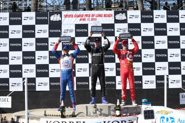 Simon Pagenaud, Scott Dixon, and Helio Castroneves hoist their trophies in Victory Circle following the Toyota Grand Prix of Long Beach -- Photo by: Chris Jones