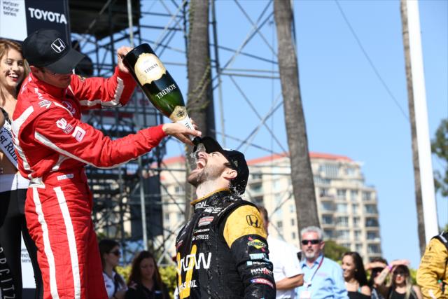 James Hinchcliffe gets a champagne shower from Sebastien Bourdais in Victory Lane following his win in the Toyota Grand Prix of Long Beach -- Photo by: Chris Jones