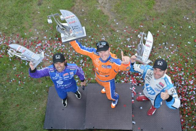 Charlie Kimball, Simon Pagenaud, and Dario Franchitti raise their trophies from the 2013 Honda Indy 200 at Mid-Ohio -- Photo by: John Cote