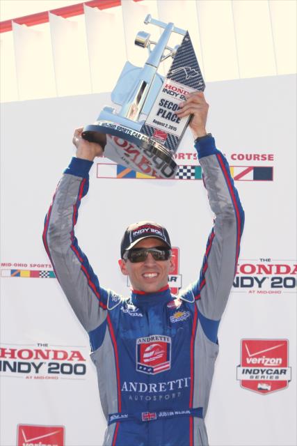 Justin Wilson hoists his second place trophy in Victory Circle following the Honda Indy 200 at Mid-Ohio -- Photo by: Chris Jones