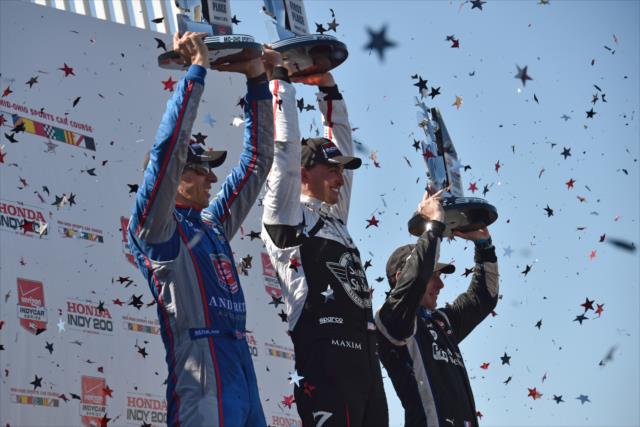 The podium of Graham Rahal, Justin Wilson, and Simon Pagenaud hoist their trophies in Victory Circle following the Honda Indy 200 at Mid-Ohio -- Photo by: John Cote