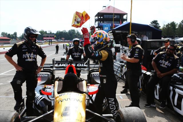 James Hinchcliffe tosses Tim Horton's TimBits back to his crew on pit lane prior to the final warmup for the Honda Indy 200 at Mid-Ohio -- Photo by: Chris Jones