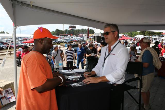 Racing legend Gil de Ferran signs an autograph in the INDYCAR Fan Village at the Mid-Ohio Sports Car Course -- Photo by: Chris Jones