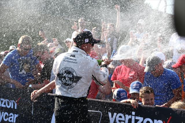 Graham Rahal with a champagne spray for the fans gathered around Victory Circle after the Honda Indy 200 at Mid-Ohio -- Photo by: Chris Jones