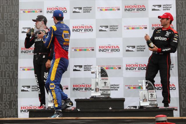 Alexander Rossi, Robert Wickens, and Will Power spray the champagne in Victory Circle following the Honda Indy 200 at Mid-Ohio -- Photo by: Chris Jones