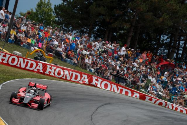 Mario Andretti pilots the two-seater over the Turn 5 hill during the parade laps prior to the start of the Honda Indy 200 at Mid-Ohio -- Photo by: Joe Skibinski
